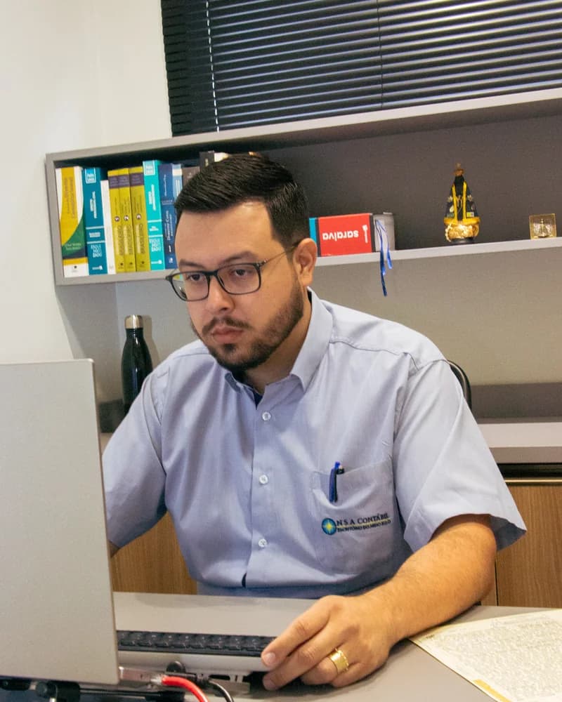 Contador da NSA Contábil analisando documentos de abertura de empresa no escritório