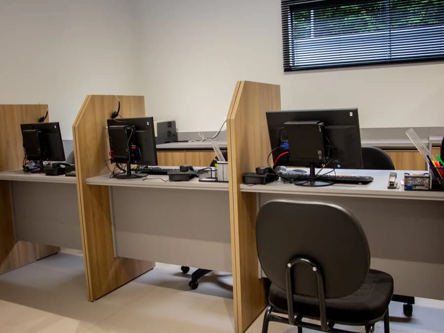 Estações de trabalho da equipe da NSA Contábil, com computadores e divisórias em madeira